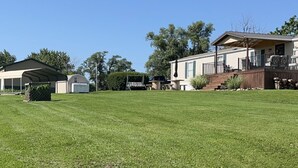 A residential property with a large lawn, a covered patio, a deck, and a garage. -  Lake Rathbun Get Away  (Rathbun)