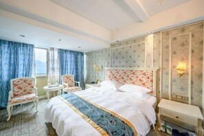 A hotel room with a large bed, two chairs, a small table, and a bench. - Xiang Shan Hotel (Zhong County)