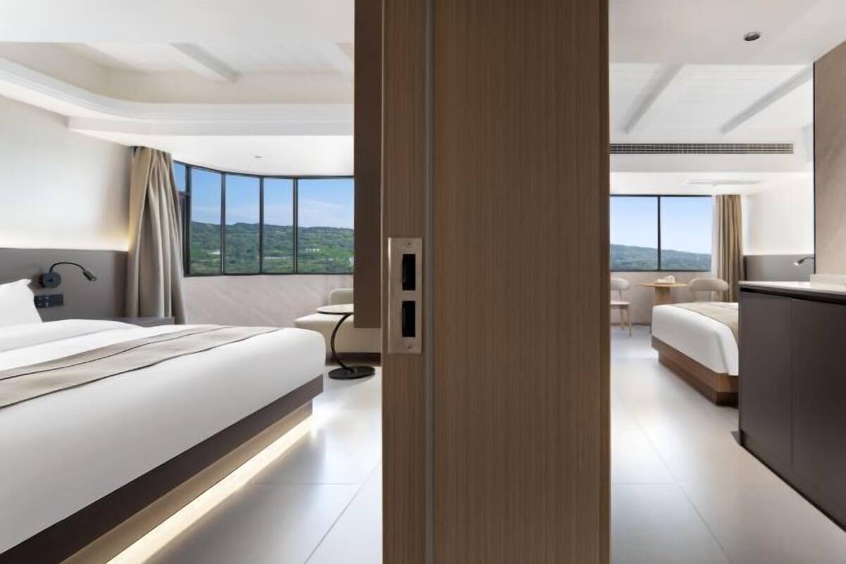 Ein modernes Hotelzimmer mit einem großen Bett, einem Schreibtisch und Bergblick.