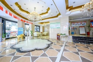 A hotel lobby with a chandelier, a reception desk, and a patterned floor. - Xiang Shan Hotel (Zhong County)
