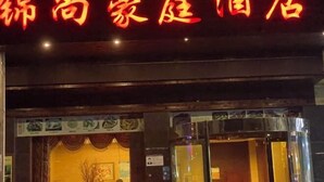 A hotel entrance with a neon sign in red and yellow. - Jinshang Haoting Hotel (Wuyi)