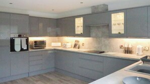 Una cocina moderna con electrodomésticos integrados, una isla central y un amplio ventanal.