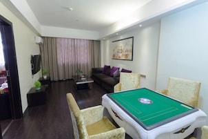 A pool table with four chairs, a sofa, a television, and a painting on the wall.