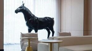 A modern living room with a sofa, two gold-trimmed tables, and a black horse sculpture. - Chibi Lake Holiday Hotel (Xinjiekou Commercial Street) (Chibi)