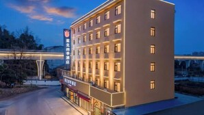 A multi-story hotel with a modern facade, illuminated windows, and a prominent sign. - Chibi Lake Holiday Hotel (Xinjiekou Commercial Street) (Chibi)