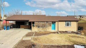 A two-story house with a garage, a front porch, and a small front yard. - Bright & Cozy Upper Unit in Denver (Denver)