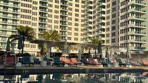 Un hôtel de grande hauteur doté d’une piscine, de nombreux balcons et d’espaces de détente en plein air.
