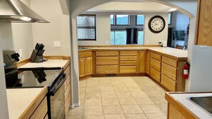 A modern kitchen with wooden cabinets, a built-in oven, and a clock on the wall. - Private Forest Cabin with Wrap-Around Deck, Fireplaces & Unlimited Hiking (Payson)