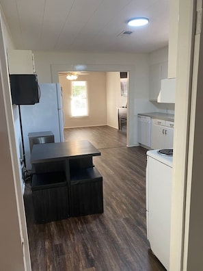 A compact kitchen with a dining table and a built-in oven. - Little Red Lake House (Greers Ferry)