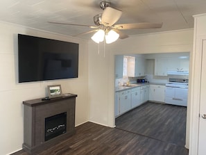 A modern kitchen with white cabinets, a built-in oven, and a ceiling fan. - Little Red Lake House (Greers Ferry)