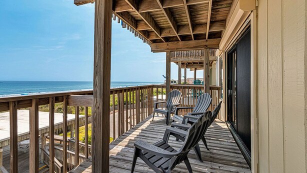 A wooden deck with chairs overlooking a beach. - 3 Bed/3 Bath ~ 2nd Floor Oceanfront Prime Condo ~ Elevator ~ 1205 Queens Court (Emerald Isle)