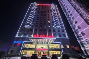 A multi-story hotel with a prominent entrance and illuminated signage. - Best International Hotel (Shangcheng, Xinyang) (Shangcheng)