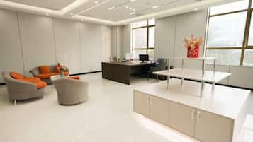 Un espacio de oficina moderno con mostrador de recepción, área de estar y ventanas amplias.