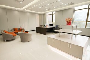 A modern office space with a reception desk, seating area, and large windows. - Best International Hotel (Shangcheng, Xinyang) (Shangcheng)