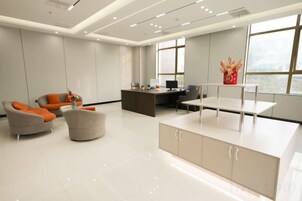 Un espacio de oficina moderno con mostrador de recepción, área de estar y ventanas amplias.
