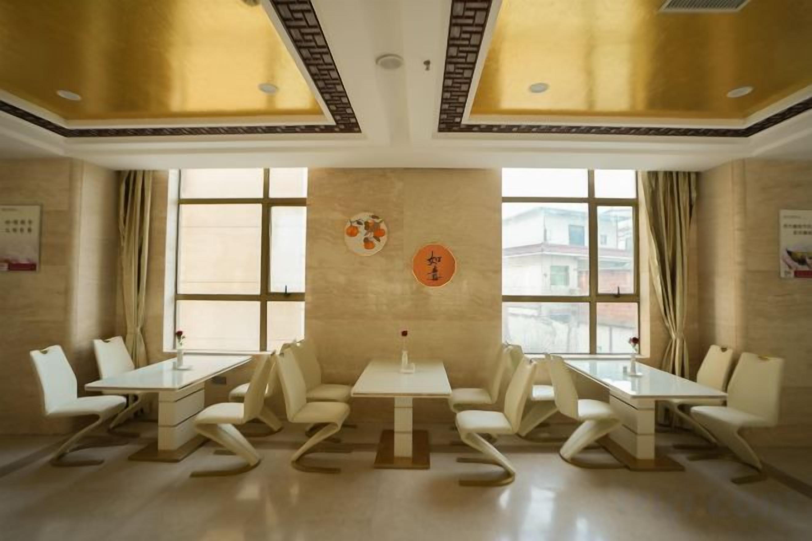 Un salón de conferencias con una larga mesa y sillas, ventanas grandes y una pared decorativa.