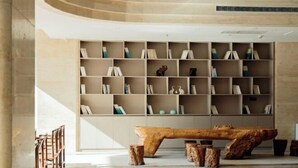 A modern library with a large wooden table and bookshelves. - Best International Hotel (Shangcheng, Xinyang) (Shangcheng)