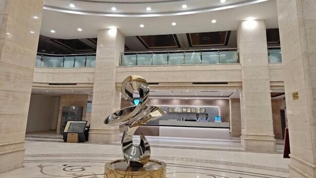 A spacious lobby with marble floors, a reception desk, and a modern sculpture. - Best International Hotel (Shangcheng, Xinyang) (Shangcheng)