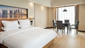 A hotel room with a large bed, a dining area with chairs, and a cityscape painting on the wall. - Best International Hotel (Shangcheng, Xinyang) (Shangcheng)
