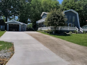 Een oprit die leidt naar een twee verdiepingen tellend huis met een garage.