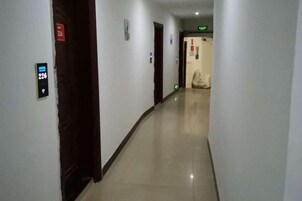 Un pasillo con puertas, un cartel que indica la habitación 226 y una señalización de salida verde.