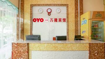 A reception desk with a marble design, a clock, and a sign with the name 'OYO' and Chinese characters.