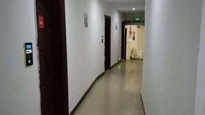 Corredor com placa indicando o número do quarto 226, sinalização de saída de emergência e uma porta com placa vermelha.