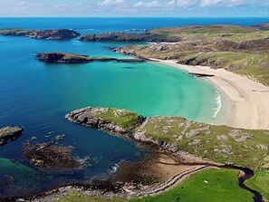 A coastal landscape with a sandy beach, rocky outcrops, and clear turquoise waters. - Cute, comfy bolthole in an amazing spot to explore from. (Kinlochbervie, near Lochinver)