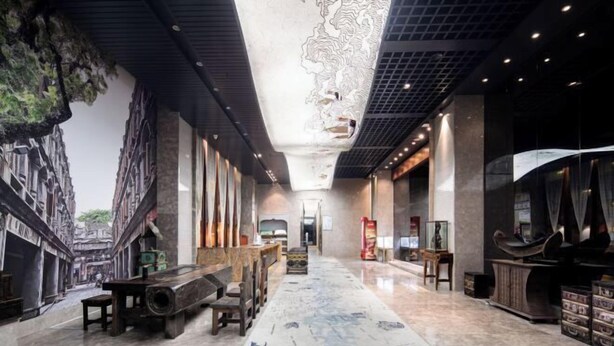 A spacious lobby with a long marble floor, a high ceiling with intricate designs, and a mural depicting a street scene. - Wen Chang Tiancheng Hotel (Wenchang High-speed Railway Station Wennan Old Street Branch) (Wenchang)