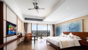 A hotel room with a large bed, a ceiling fan, a TV on the wall, and a view of the city through large windows. - Wen Chang Tiancheng Hotel (Wenchang High-speed Railway Station Wennan Old Street Branch) (Wenchang)