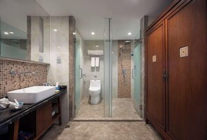 Un baño moderno con un lavamanos grande, una ducha con cerramiento de vidrio y un armario de madera.