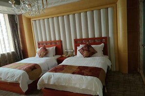 A hotel room with two beds, a chandelier, and a large window with curtains. - Bishui Lantian Hotel (Jing County)
