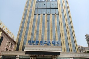 Un edificio de hotel alto con un letrero llamativo en caracteres chinos.