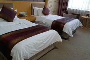 A hotel room with two beds, a nightstand, a chair, and a small table. - Bishui Lantian Hotel (Jing County)