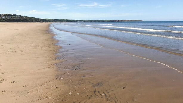 A wide sandy beach with gentle waves, a clear sky, and distant hills. - I just love the location of Arthur’s Place within ’The Bay’. (Filey)