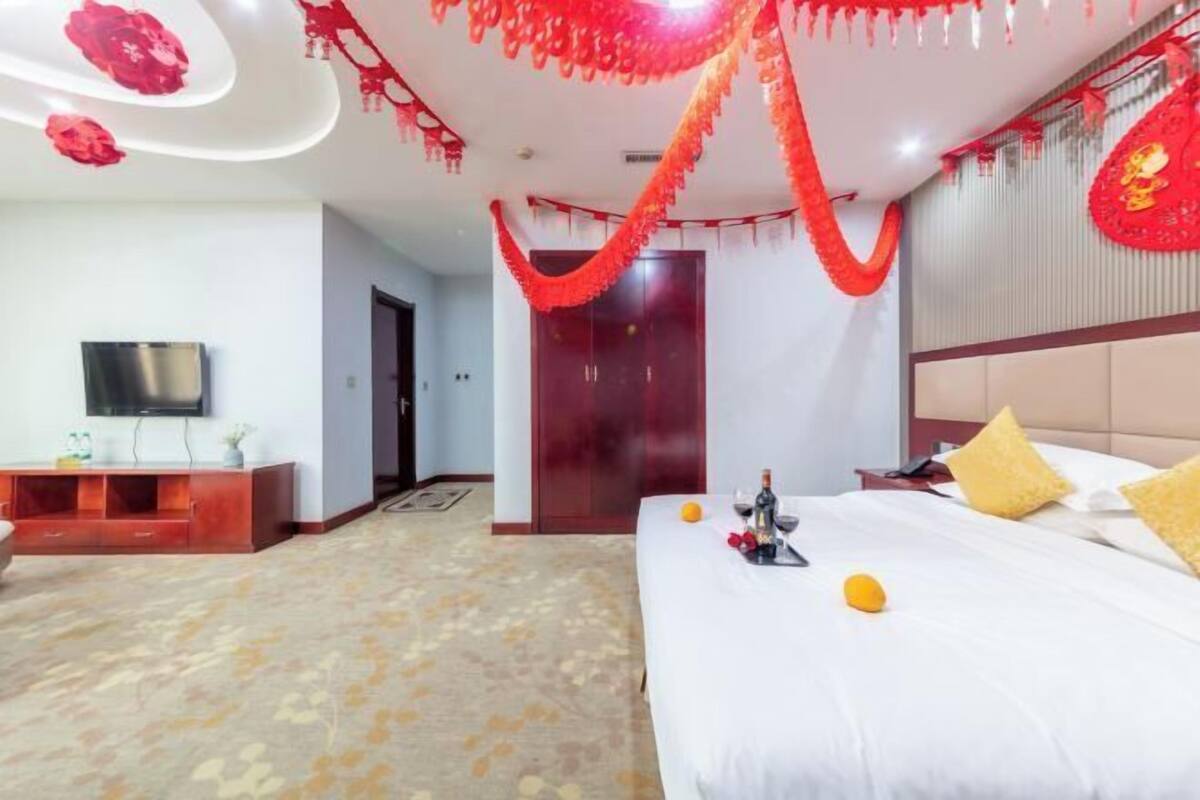 Une chambre d’hôtel équipée d’un lit, d’une télévision et d’un mini-bar.