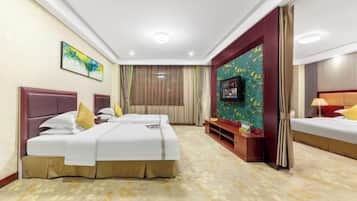 A hotel room with two beds, a TV, and a small seating area.