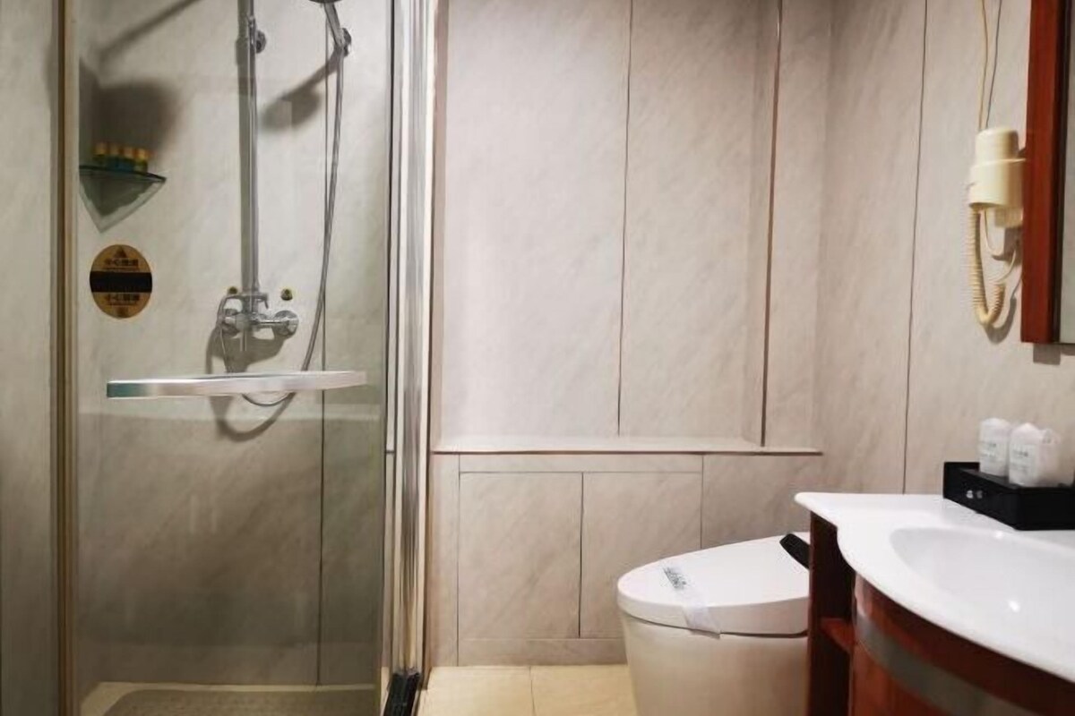 Une salle de bain avec une douche à parois de verre, des toilettes et un lavabo avec un miroir.