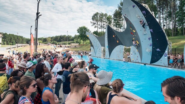A rock climbing wall with spectators by a pool. - New! Modern Large House Great Location near UNC-Charlotte, TopGolf, Carowinds (Charlotte)