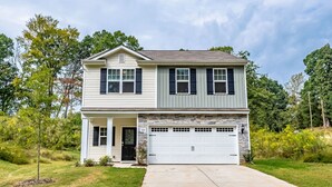A two-story house with a garage, a stone facade, and a well-maintained lawn. - New! Modern Large House Great Location near UNC-Charlotte, TopGolf, Carowinds (Charlotte)