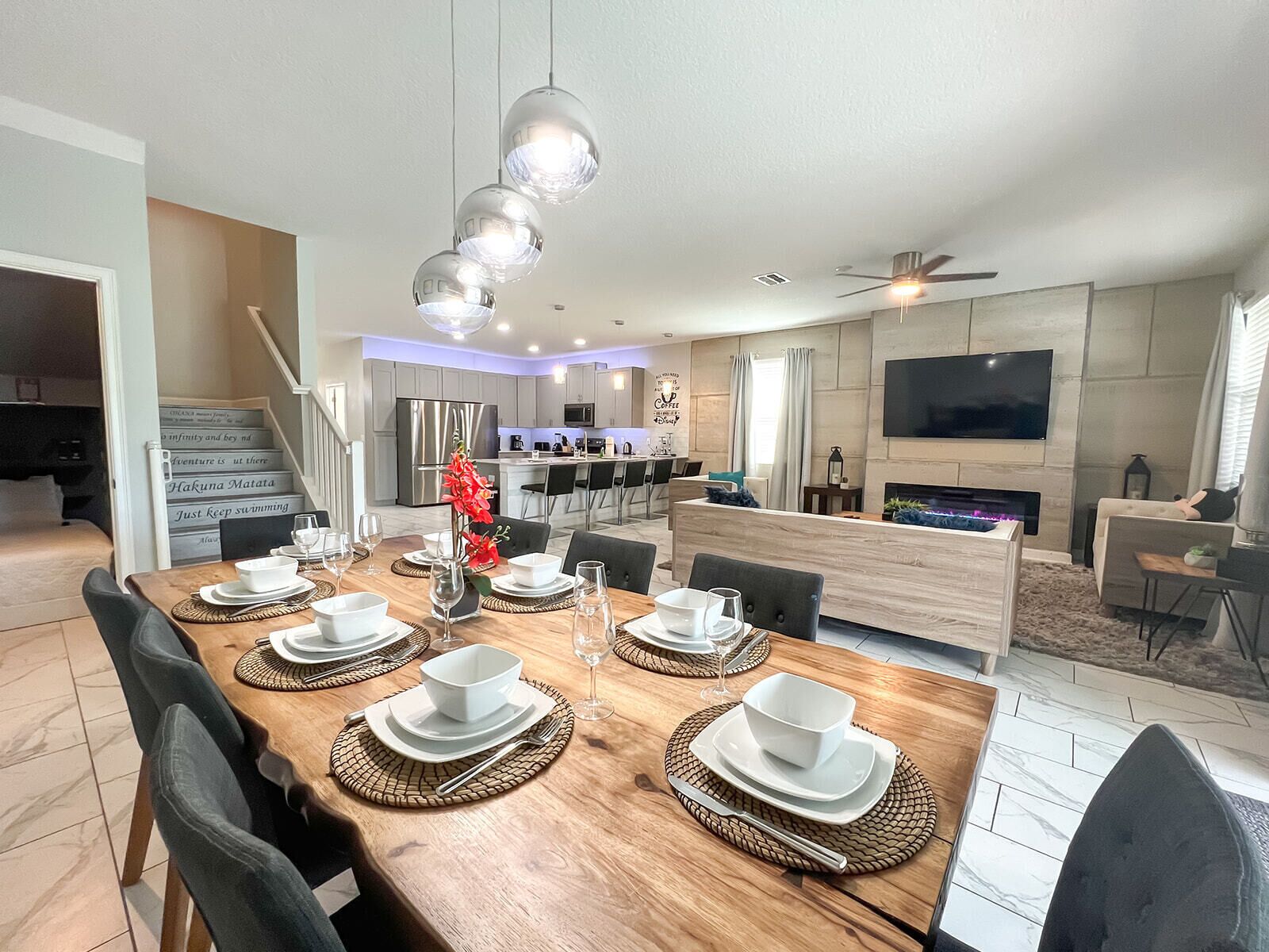 A modern dining area with a wooden table set for four, surrounded by chairs.