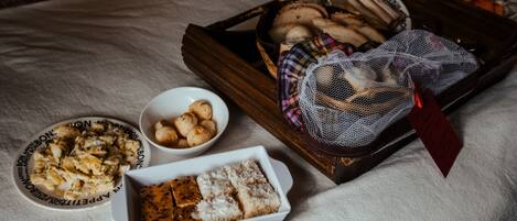 A variety of food items including bread, cheese, and fruits on a table.