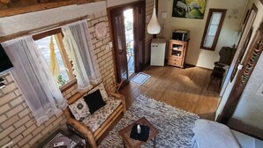 Ein gemütliches Wohnzimmer mit Holzboden, einer Couch, einem kleinen Tisch und einem Teppich.