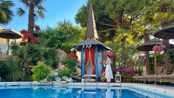 Una piscina al aire libre de temporada, sombrillas