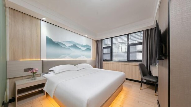 A hotel room with a large bed, bedside tables, a desk, and a TV. - Alice Hotel (Guangzhou Olympic Sports Chebei Subway Station Branch) (Guangzhou)