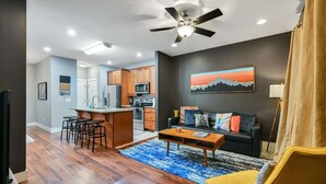 A modern living space with a kitchen, dining area, and a sofa set.