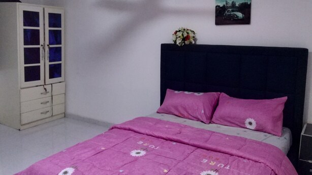 Une chambre à coucher avec un lit, une armoire et un tableau accroché au mur.