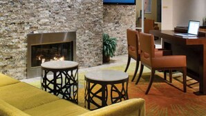 A cozy lounge area with a stone wall, a fireplace, and comfortable seating. - Marriott Desert Springs II, Luxury 1 bedroom villa (Palm Desert)