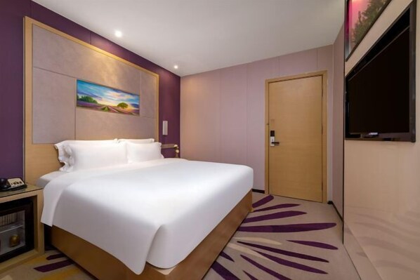 A hotel room with a large bed, a TV mounted on the wall, and a door to the right. - Lavande Hotels (Zhuhai Tangjia University Town) (Zhuhai)