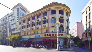 A multi-story building with a curved facade, featuring balconies and air conditioning units. - Meiguiyuan Business Hotel (Yongchun)